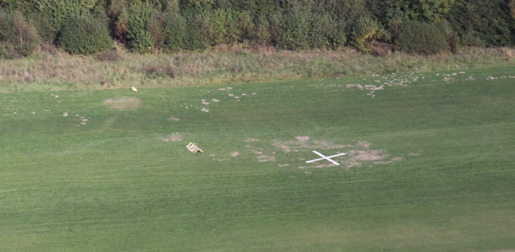 Luftaufnahme der jüngsten Wildschäden. Das weiße Kreuz signalisiert anfliegenden Piloten die Sperrung der Landebahn.